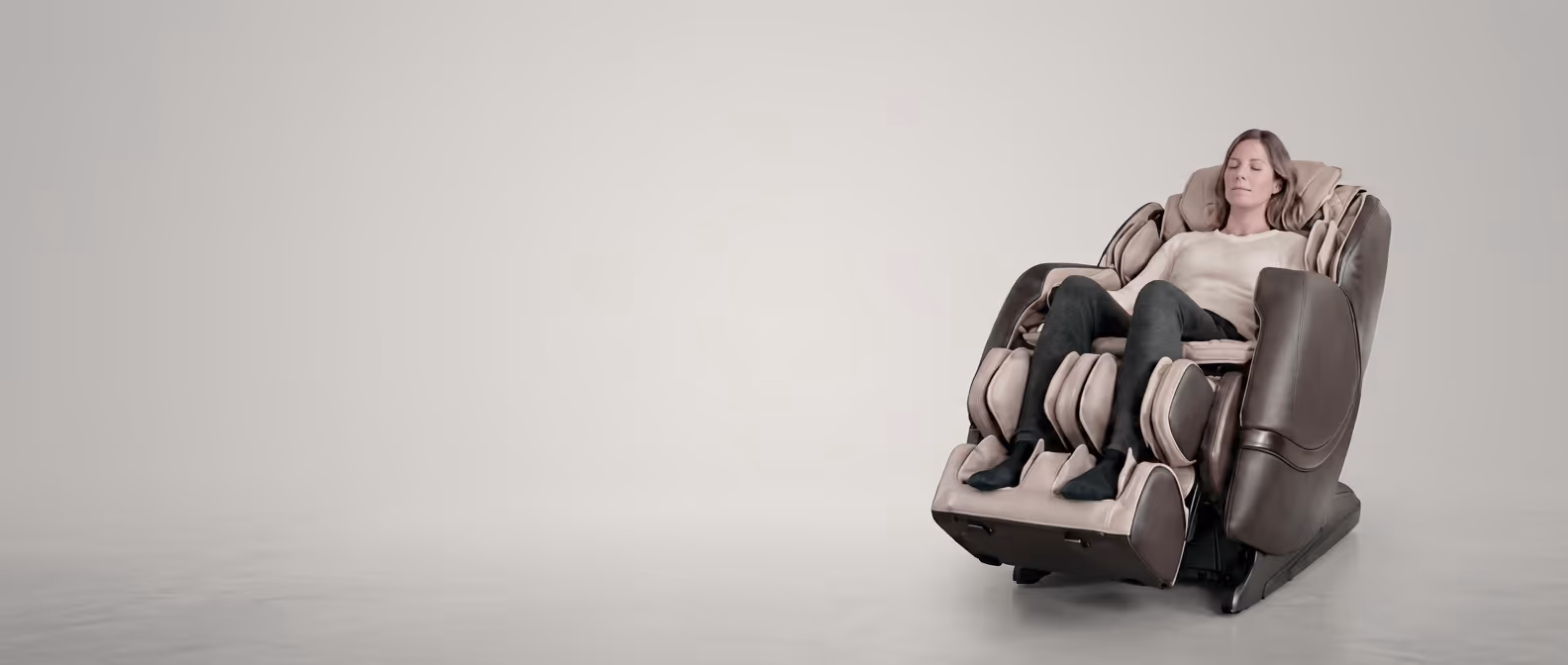 Femme détendue assise dans un fauteuil de massage Masséa marron et beige.