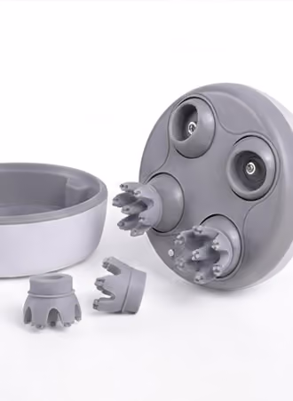 Dispositif gris avec trois têtes rotatives, pièces détachées et un support circulaire blanc.
