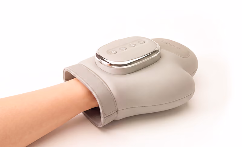 Main insérée dans un appareil de massage électrique manova avec commandes sur le dessus.