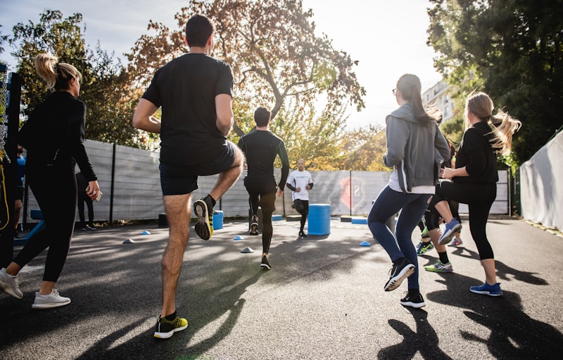Grupo de personas entrenando al aire libre con conos y steps en una sesión dirigida