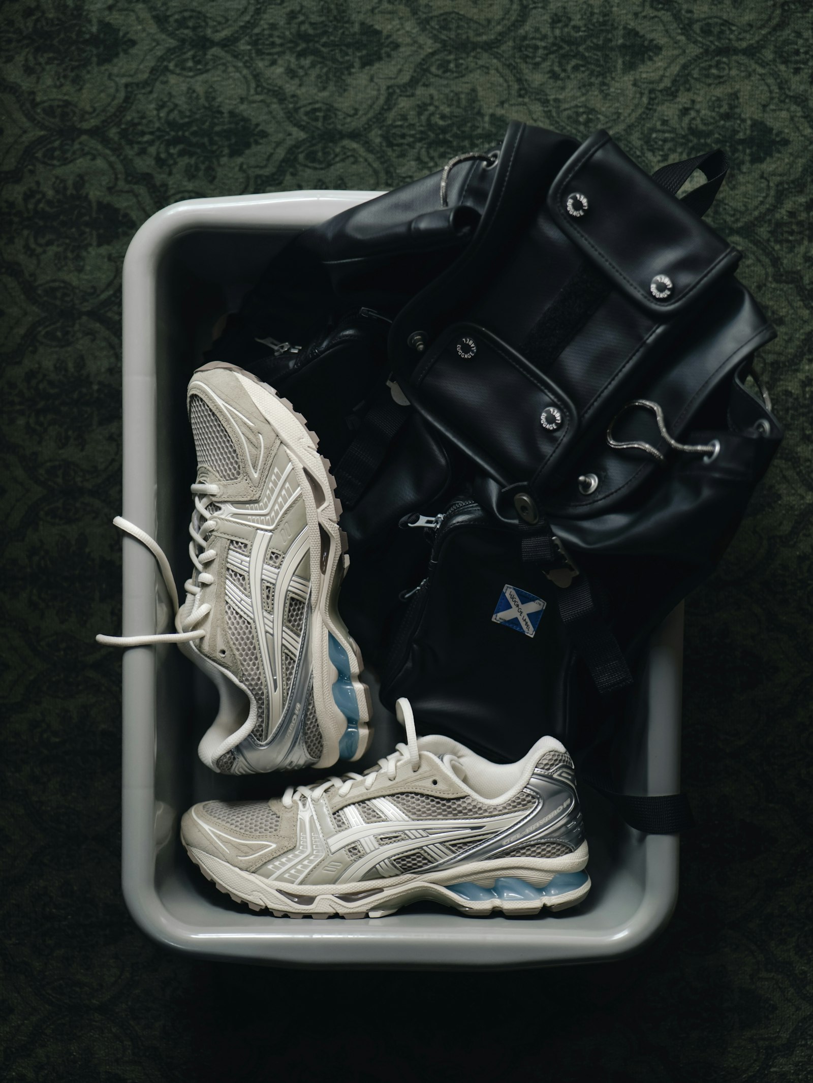 Zapatillas de deporte y una bolsa de entrenamiento negra preparadas sobre una bandeja