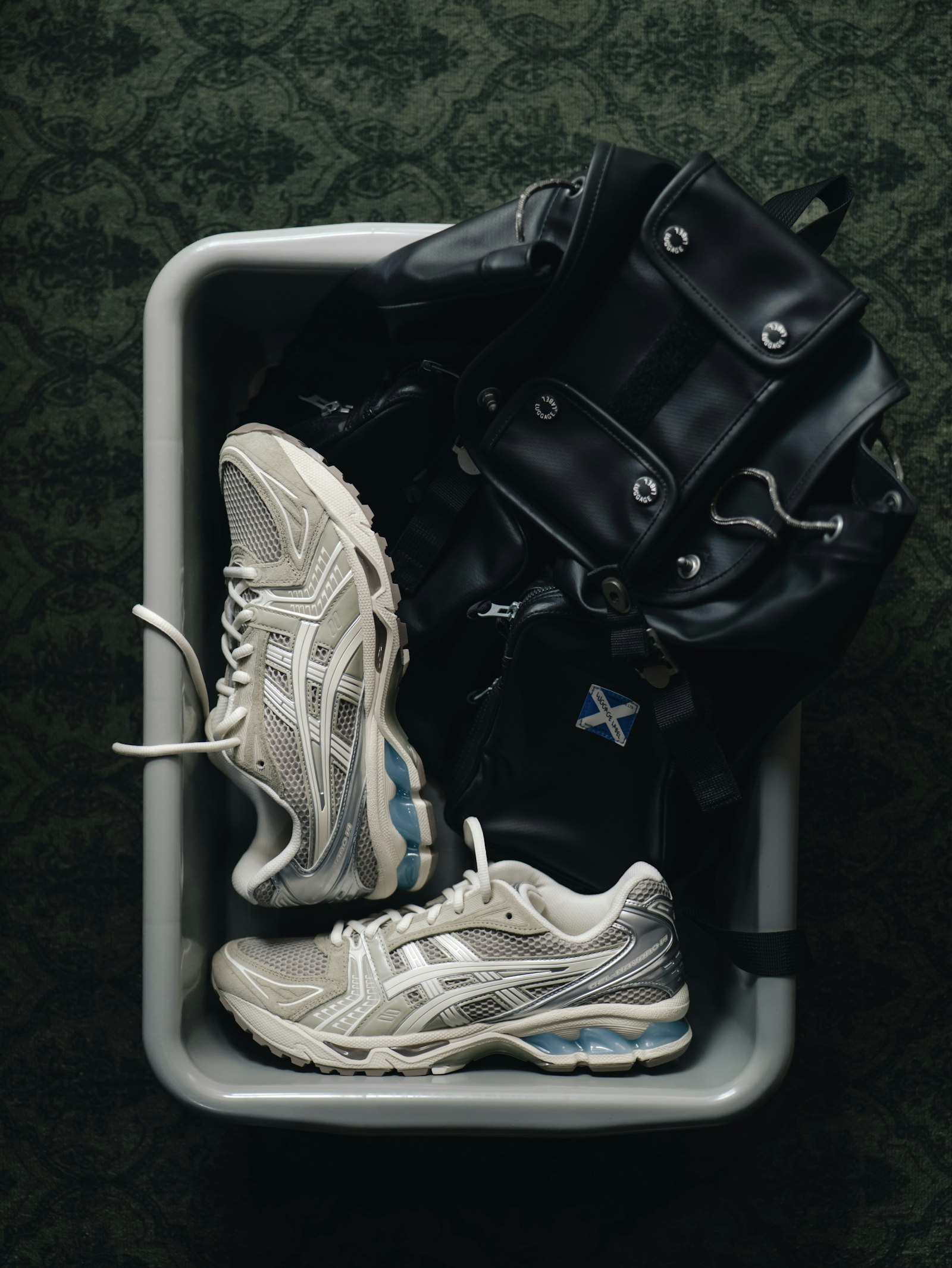 Zapatillas de deporte y una bolsa de entrenamiento negra preparadas sobre una bandeja