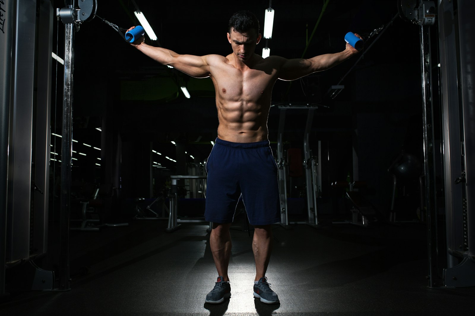 Hombre entrenando fuerza con máquina de poleas en un gimnasio