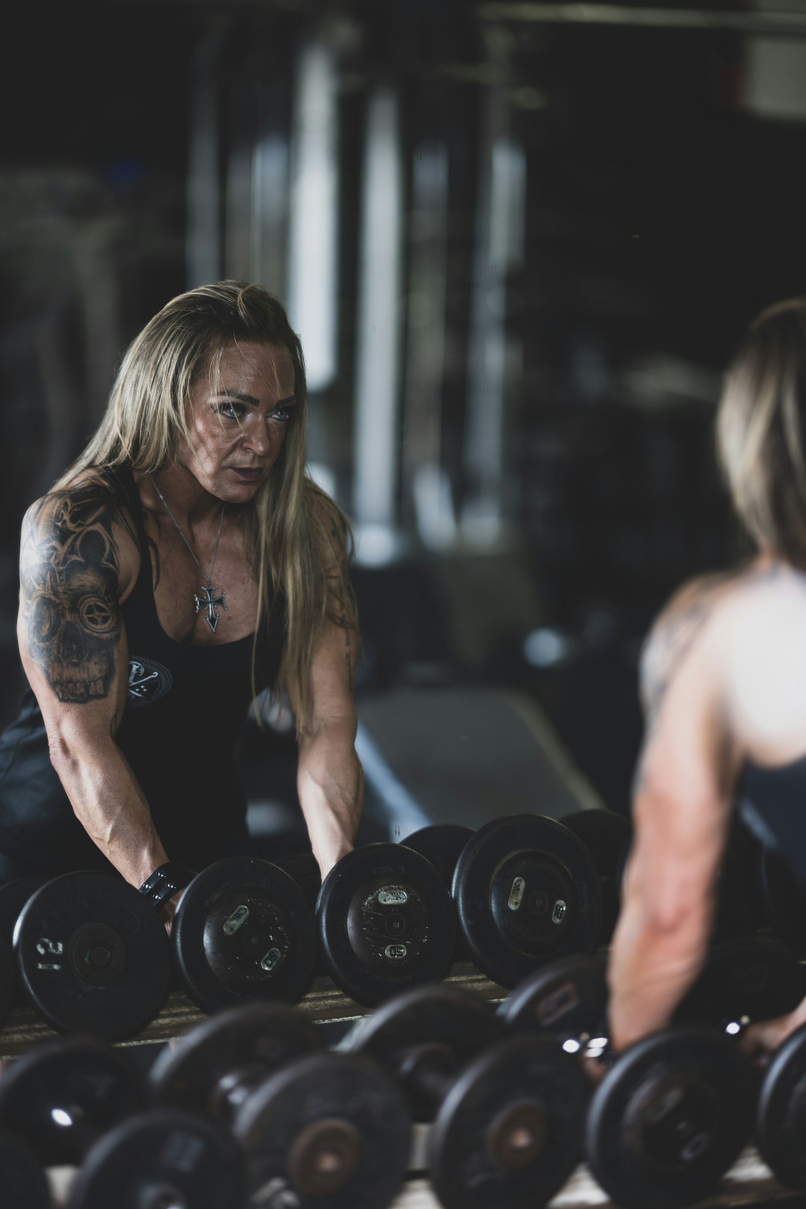 Mujer madura entrenando con mancuernas en un gimnasio