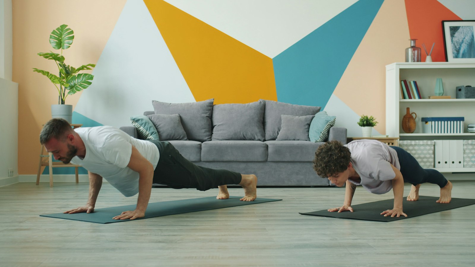 Dos personas haciendo flexiones sobre esterillas en el salón de casa
