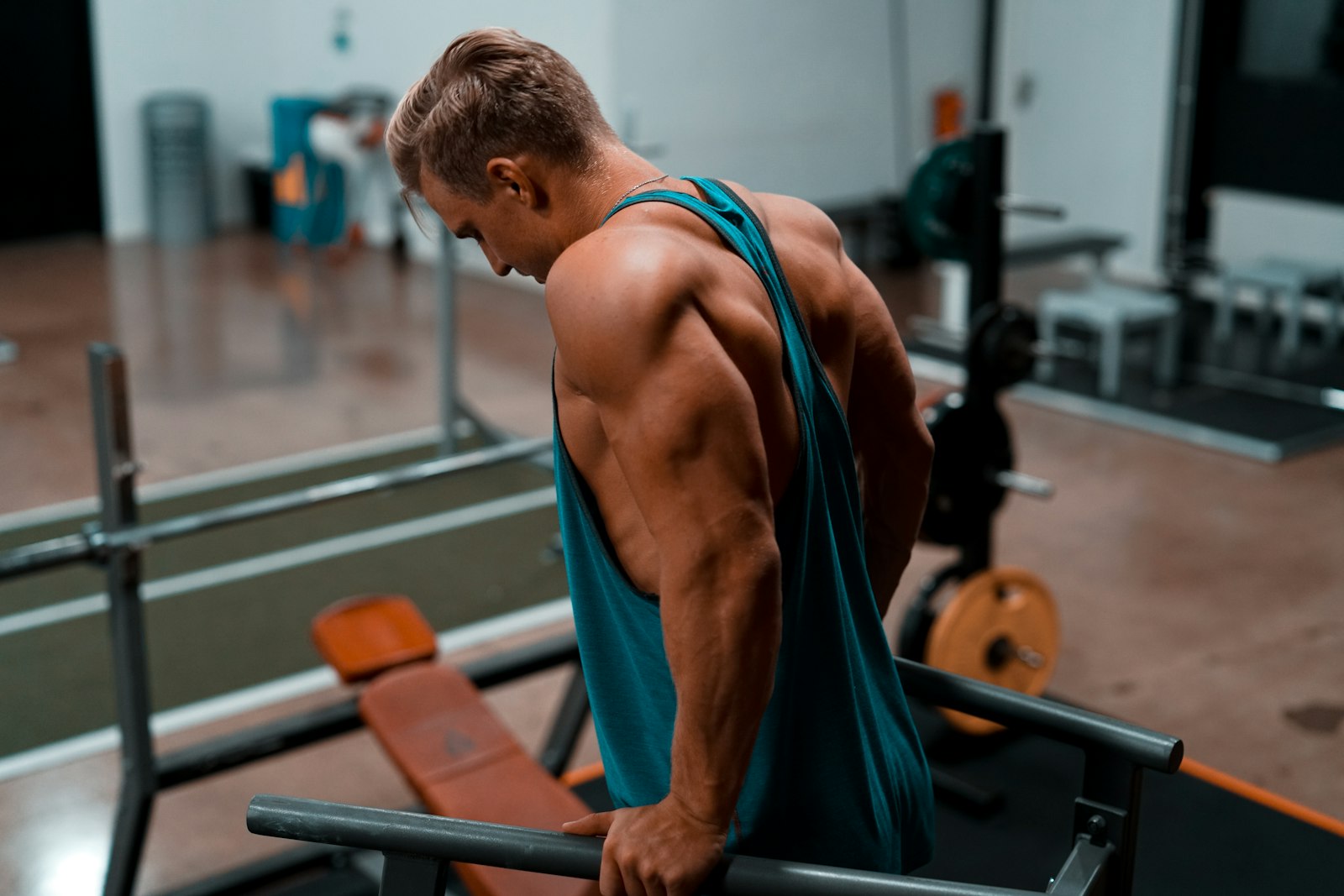 Hombre haciendo fondos en paralelas en un gimnasio, trabajando el tríceps