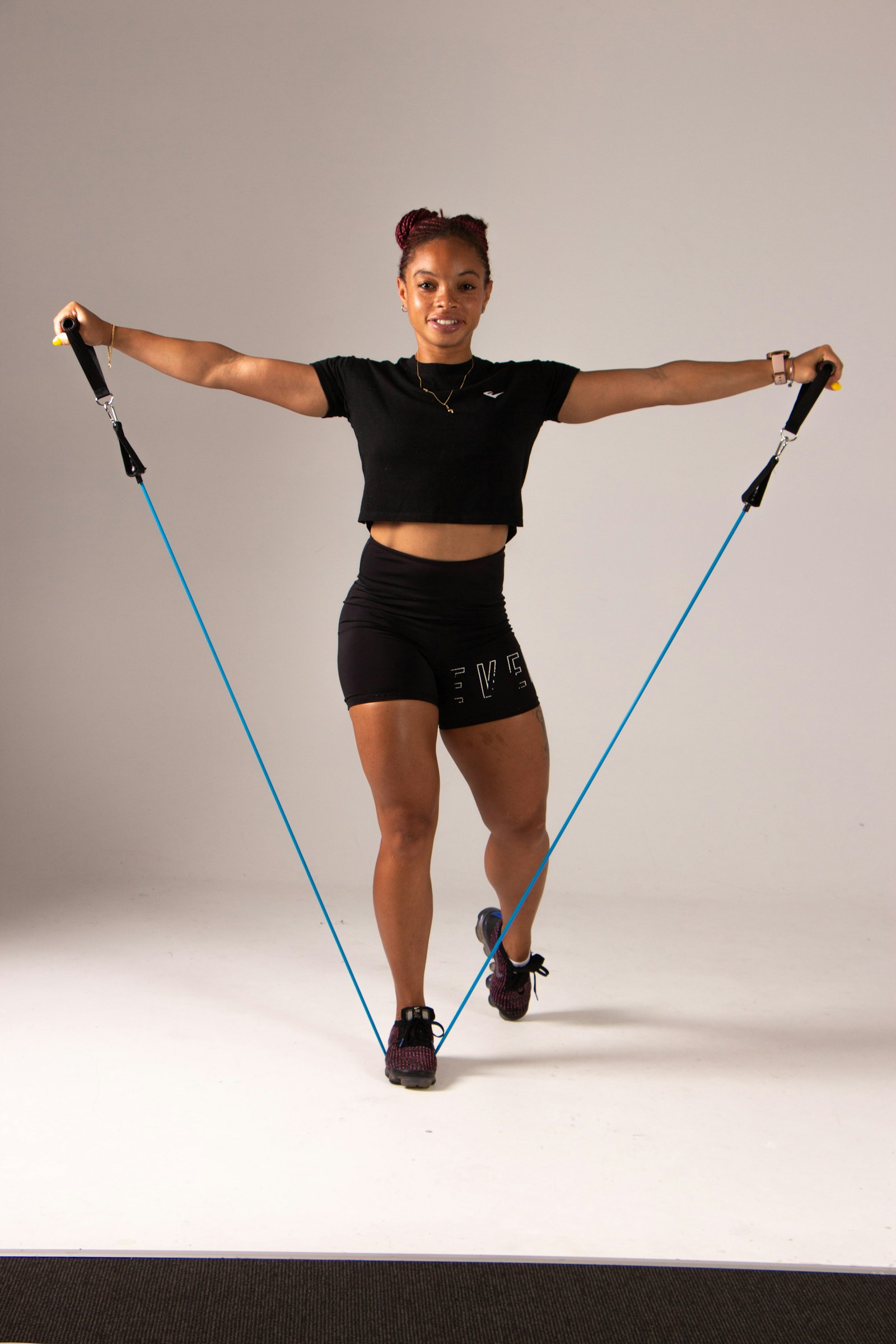 Mujer entrenando con bandas elásticas de resistencia, material compacto para viajar