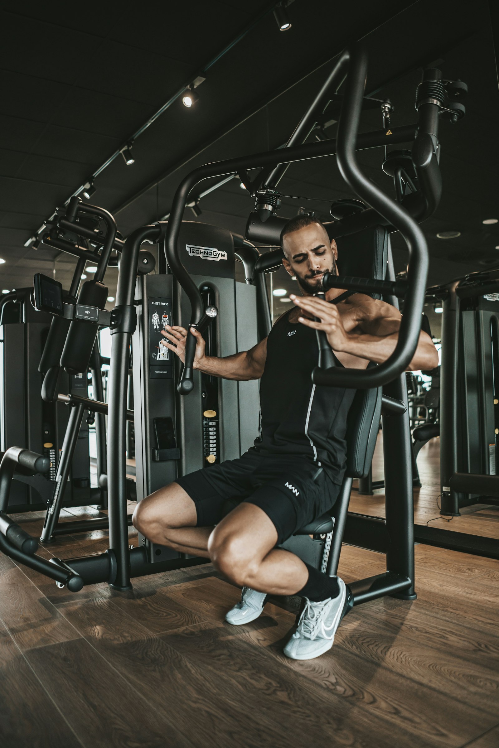 Hombre haciendo press inclinado en una máquina de pecho en un gimnasio