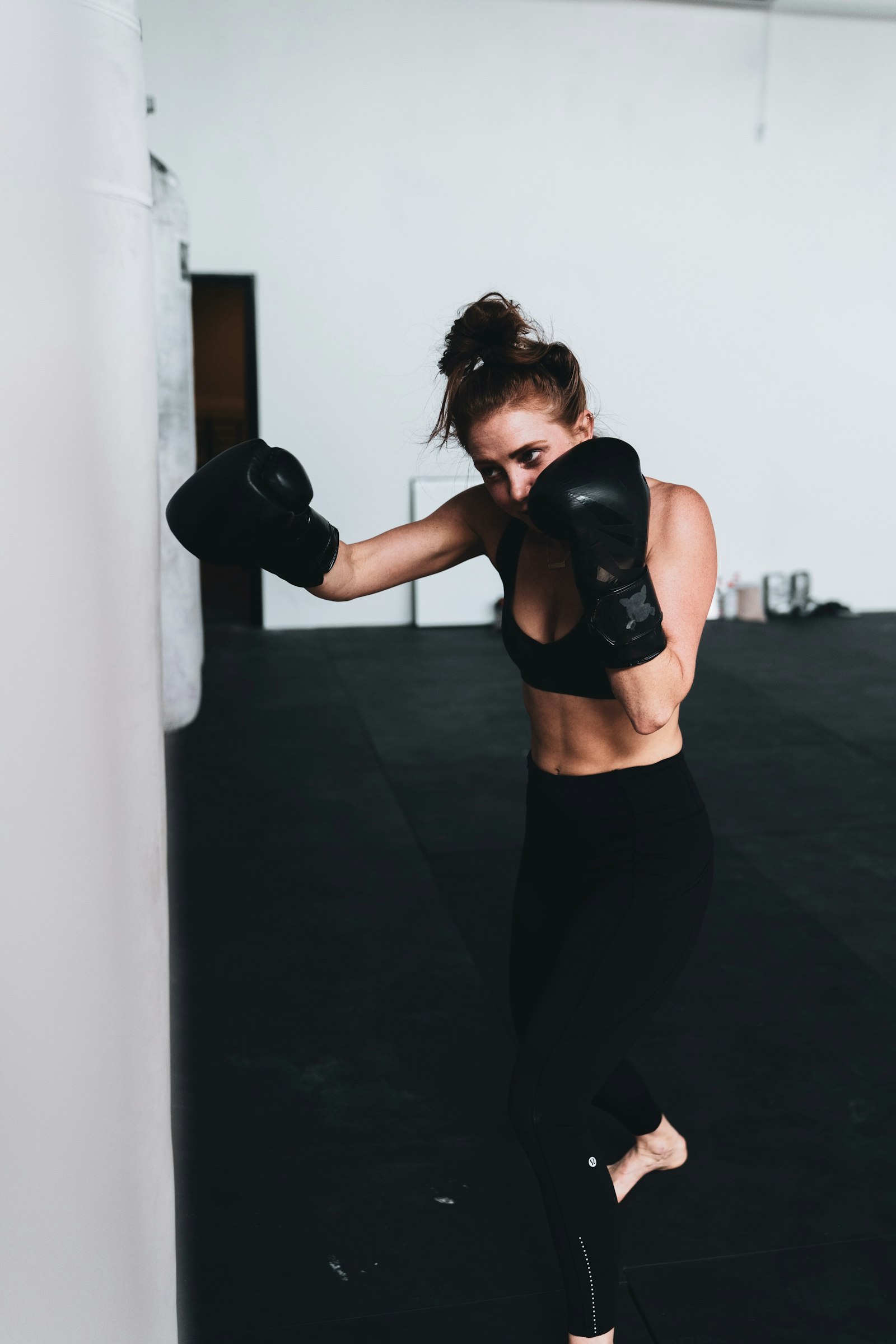 Mujer boxeadora golpeando un saco de boxeo durante un entrenamiento