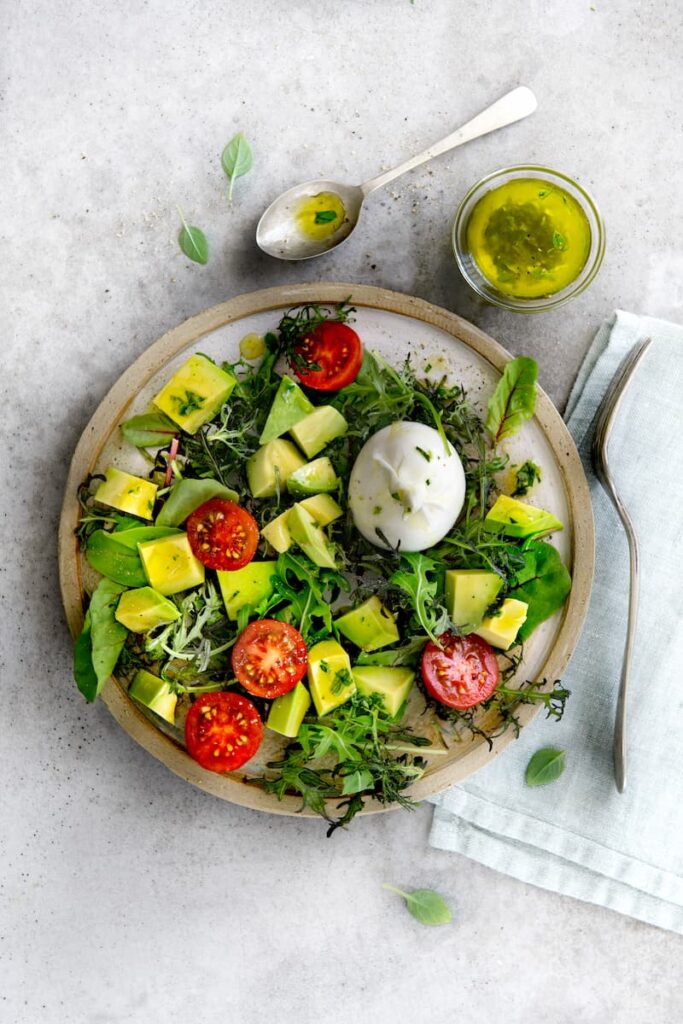Green salad with avocado and mini burrata