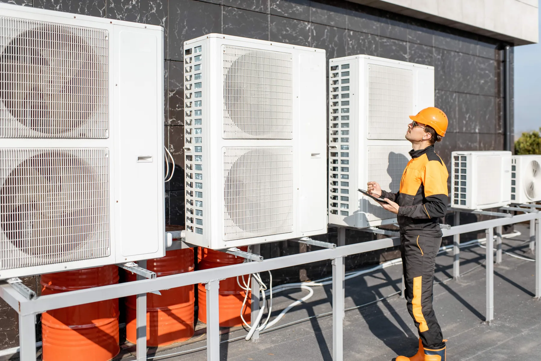 Technician inspecting rooftop HVAC units