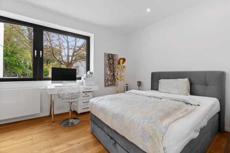 Schlafzimmer mit Boxspringbett und großem Fenster