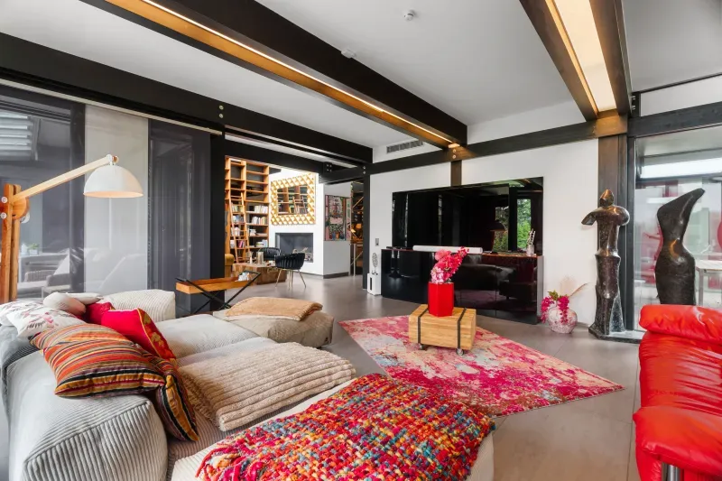 Wohnzimmer mit Sofalandschaft, Kamin und Kunst