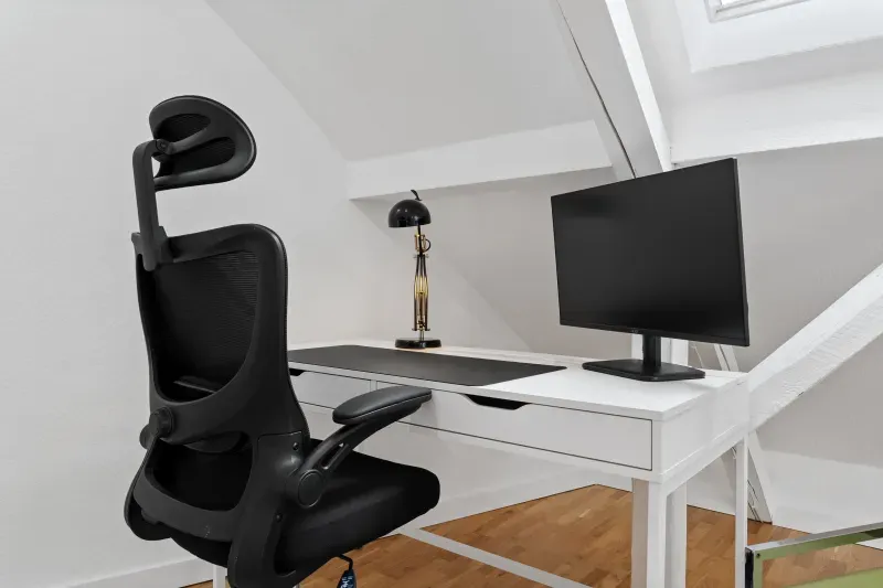 Arbeitsplatz unter der Dachschräge mit Schreibtisch und Monitor