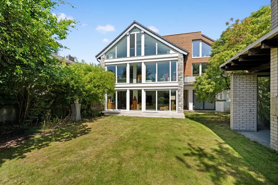 Gartenansicht eines Einfamilienhauses mit großer Glasfront