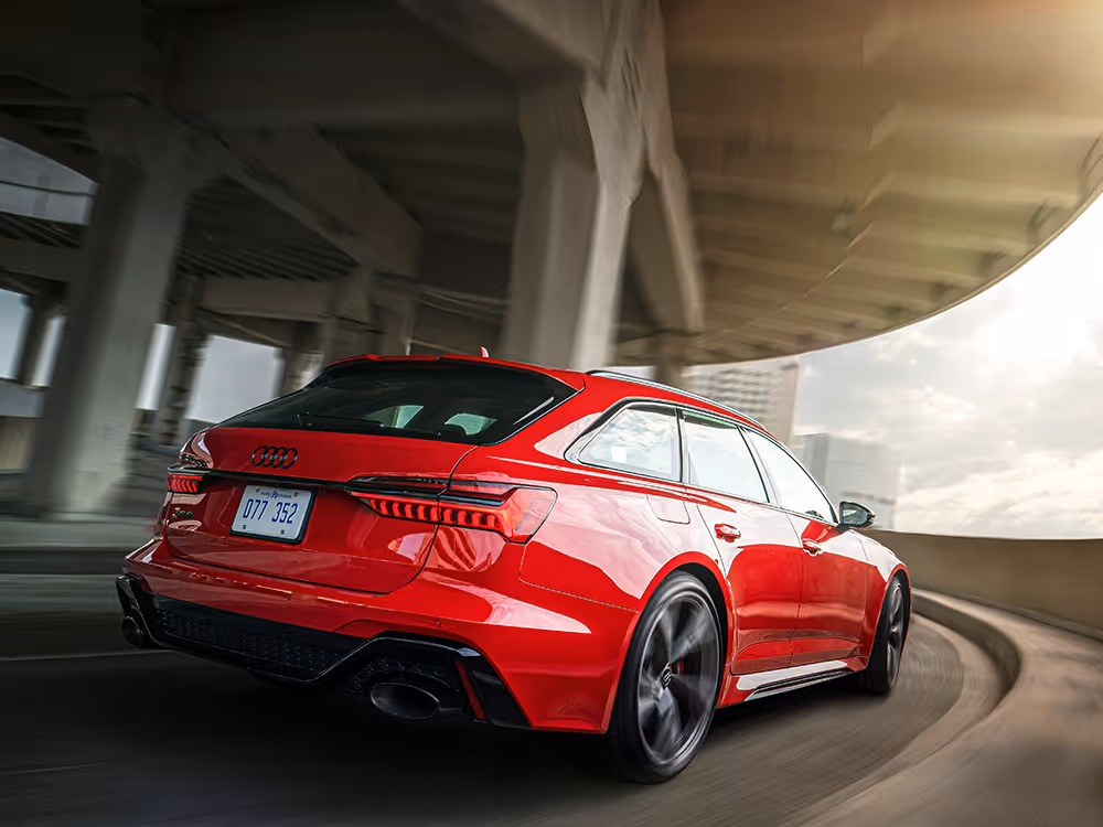 Red Audi wagon speeding through city underpass, motion automotive photography with dynamic perspective by Roe Photo.