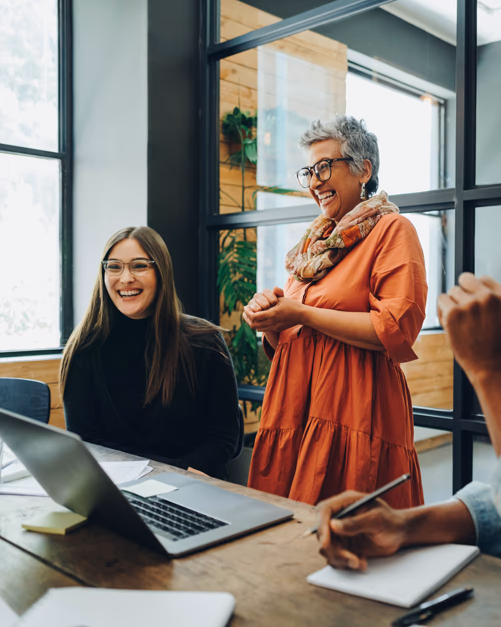 coffee shop owner is smiling and is handing over the coffee