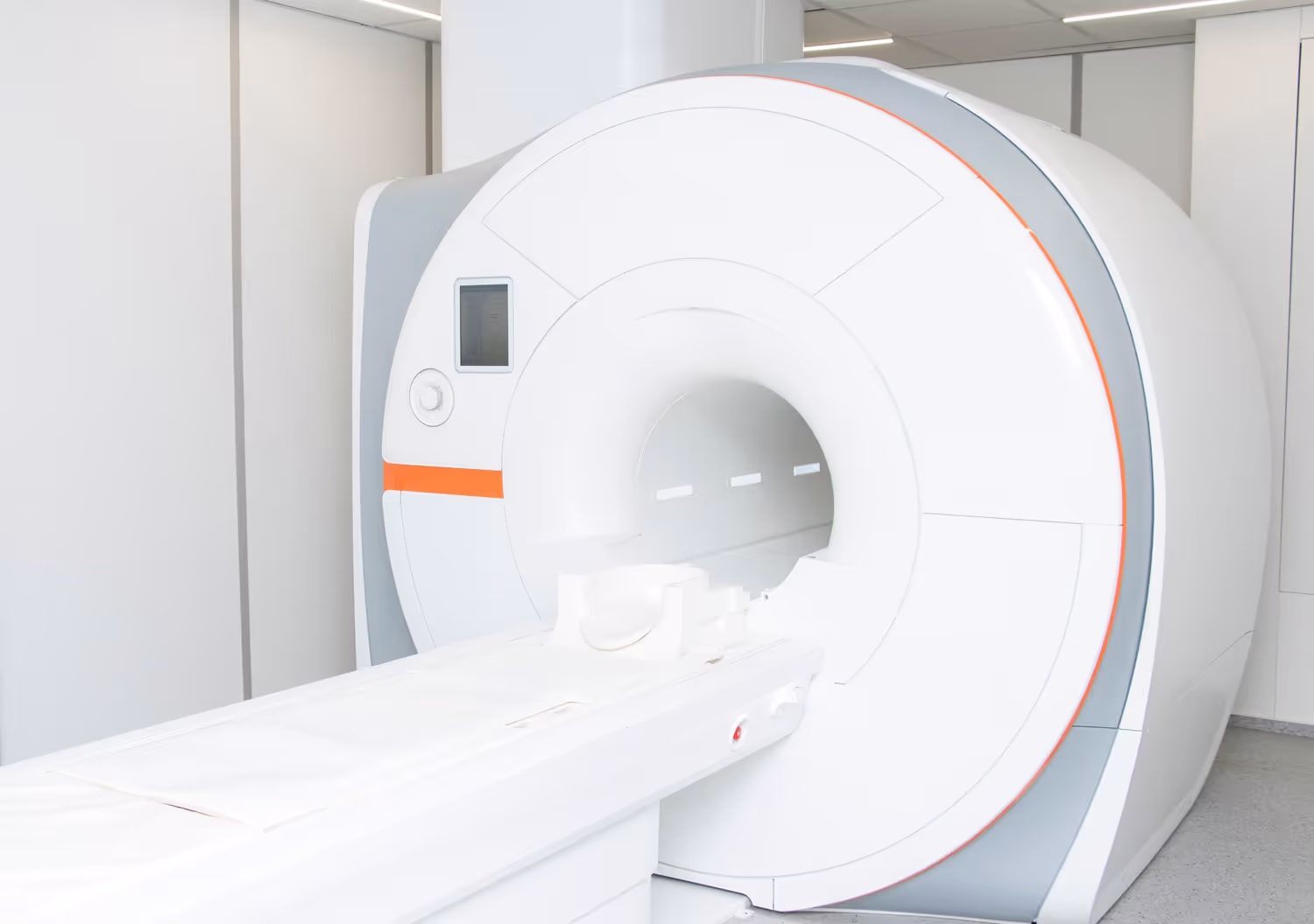 Modern white MRI scanner in a clean, bright medical room.