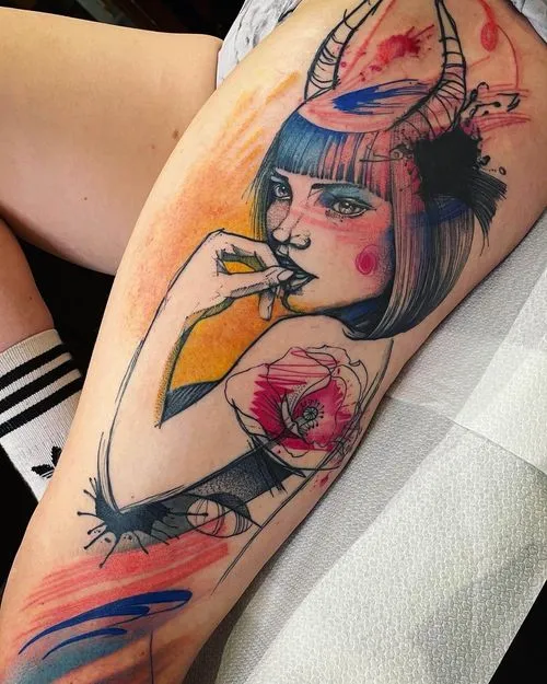 Colorful tattoo of a woman with short hair and horns, holding her finger near her lips, with abstract floral and paint splash elements on a thigh.