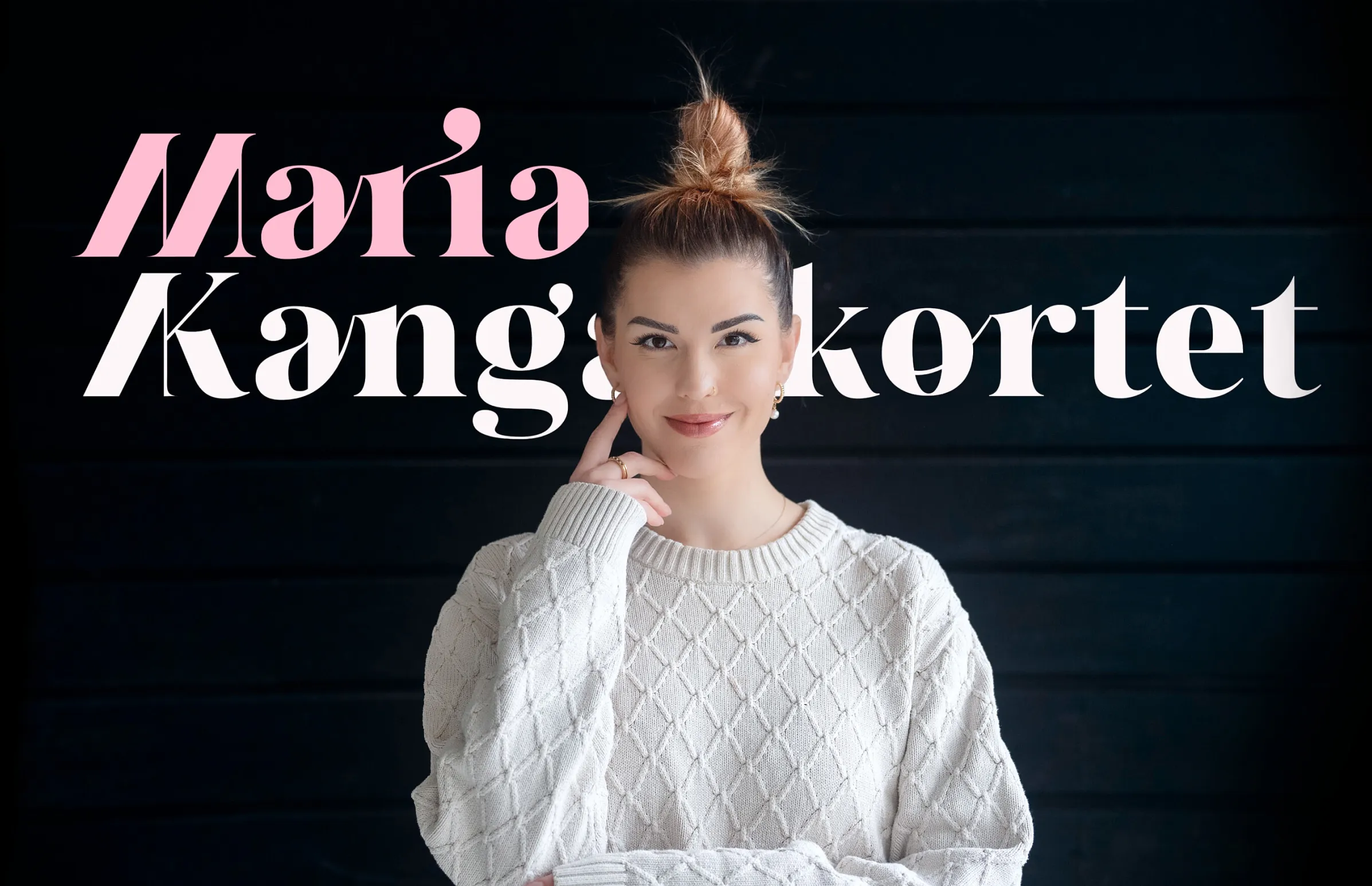 Smiling woman with a messy bun hairstyle wearing a white textured sweater against a dark background with text 'Maria Kanga kortet'.