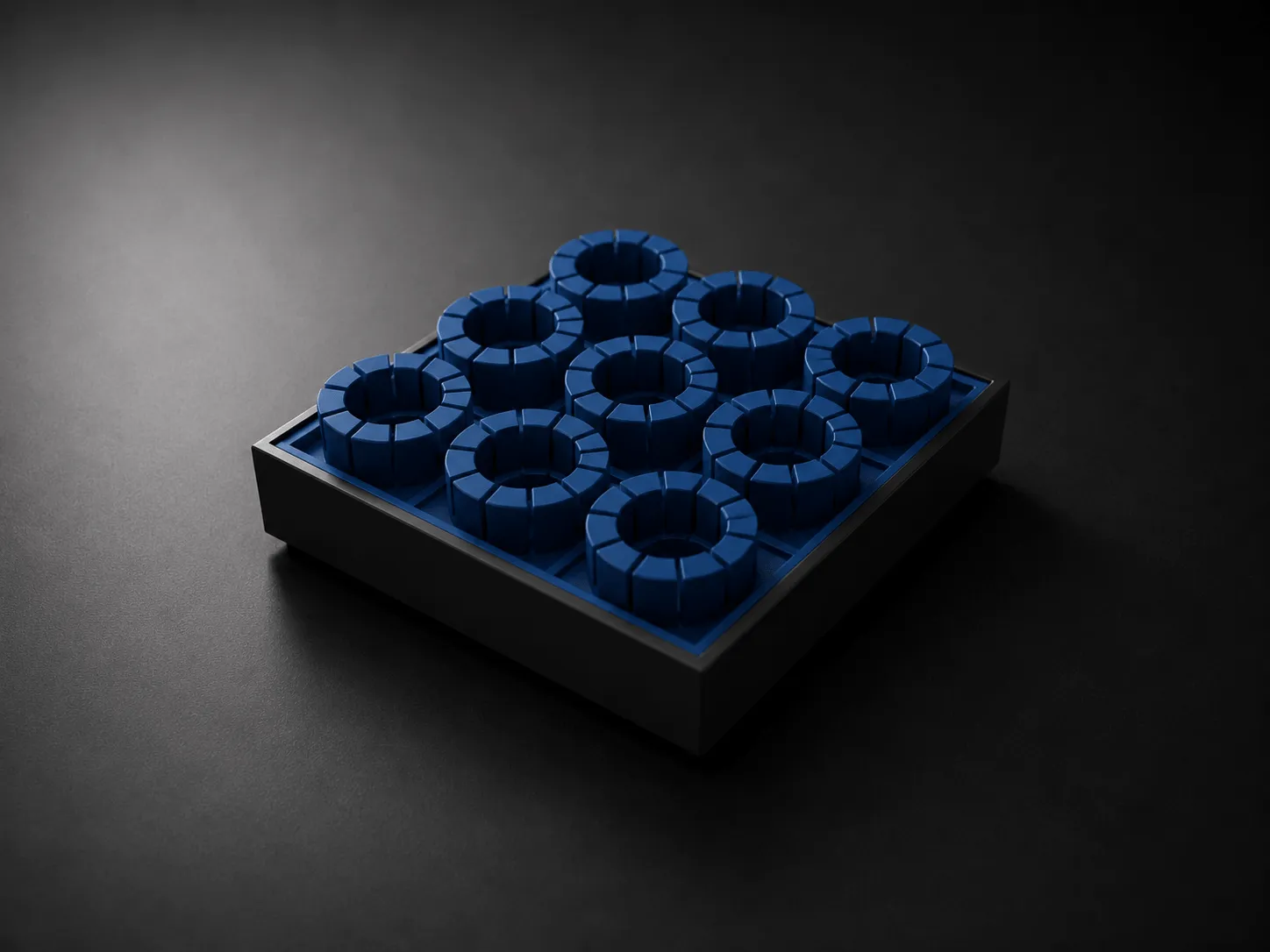 Rolled open black silicone mat with rounded corners on a white surface.