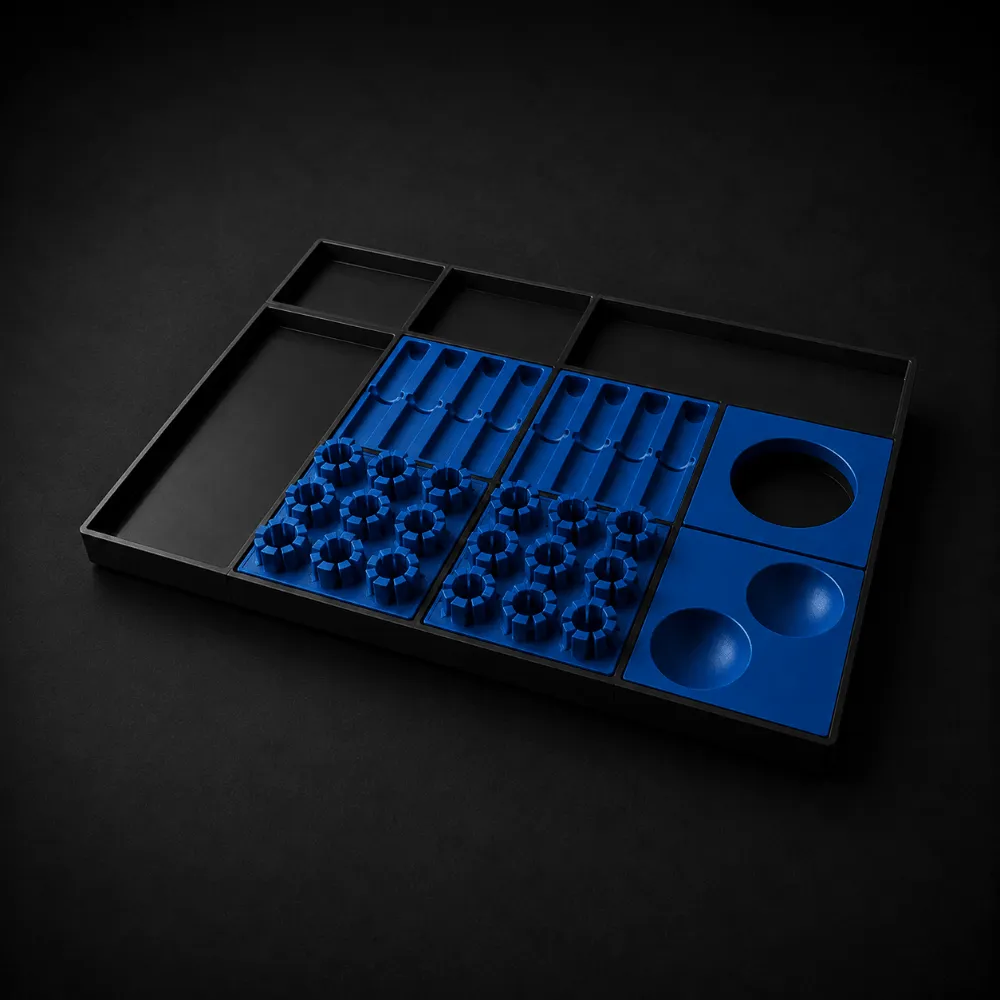 Black tray with organized blue holders featuring various shaped slots and circular indentations.