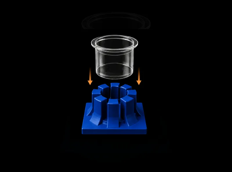 Transparent cup positioned above a segmented blue circular base with orange arrows pointing down.