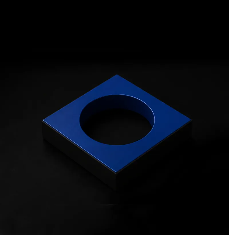 Blue square cup holder with a circular opening in the center on a black background.