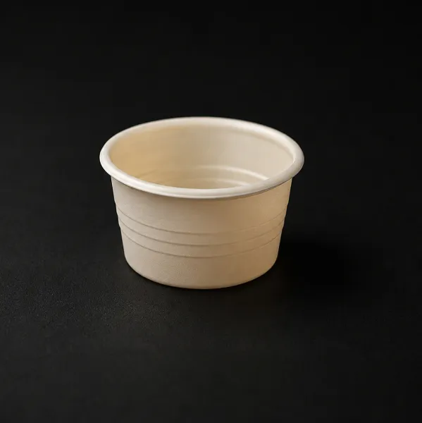 Small beige disposable rinse cup on a black surface.