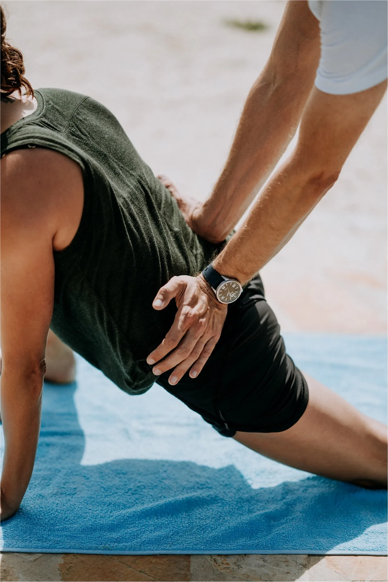 Physiotherapist supporting a patient during a floor-based exercise