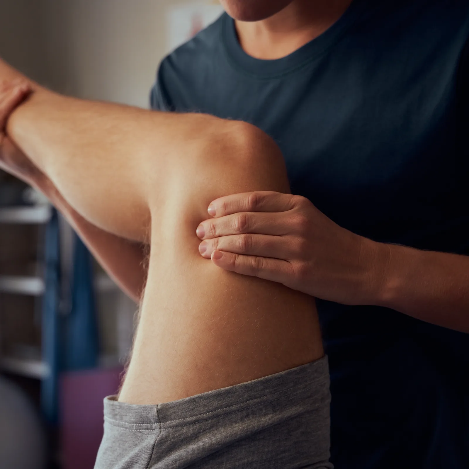 Physiotherapist assessing a patient's knee during a movement examination