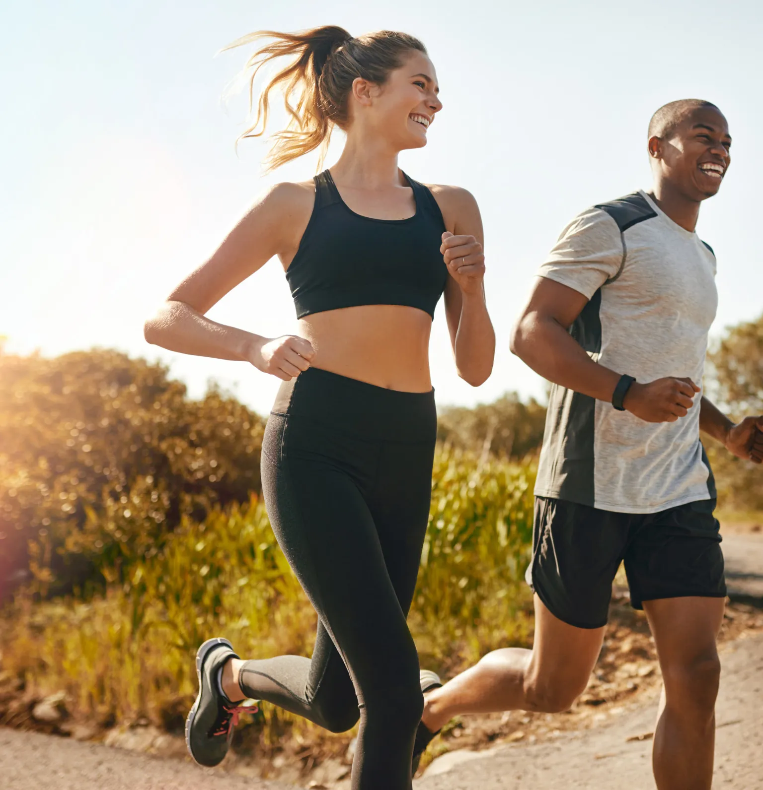 Smiling young woman and man jogging outdoors on a sunny day after a DEXA scan