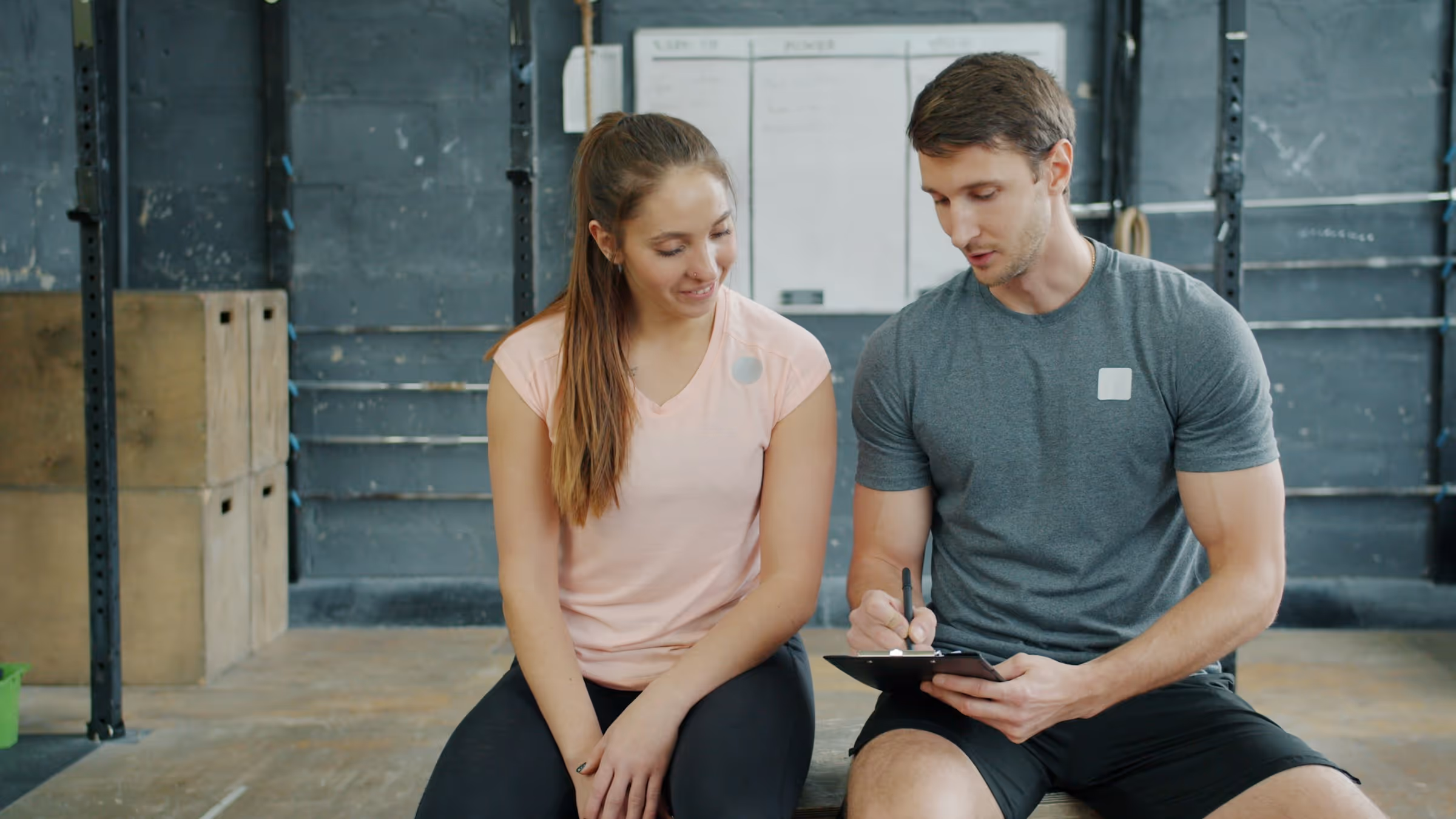 Man and woman in workout clothes going over DEXA scan results
