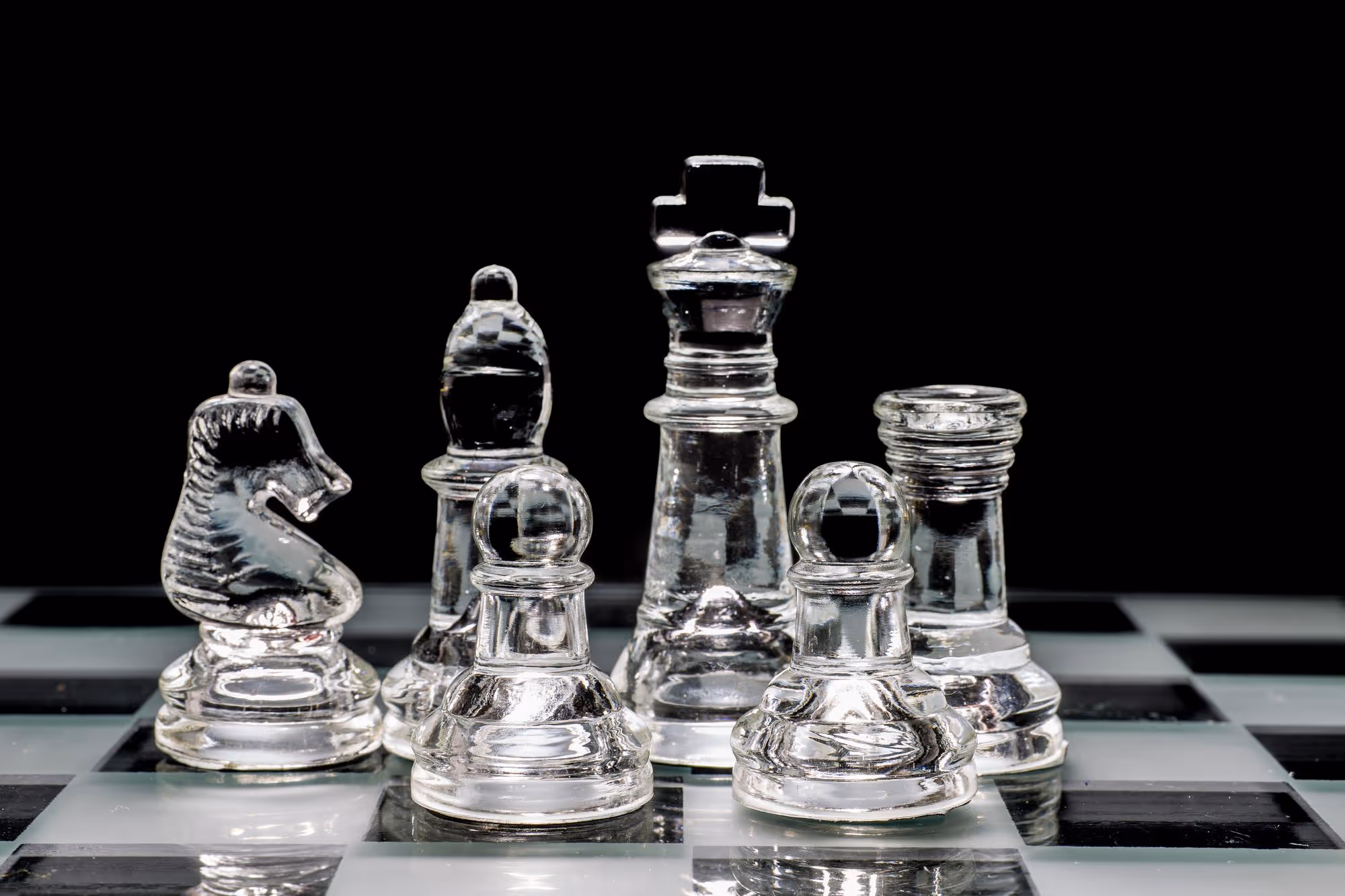 Nahaufnahme verschiedener, gläserner Schachfiguren