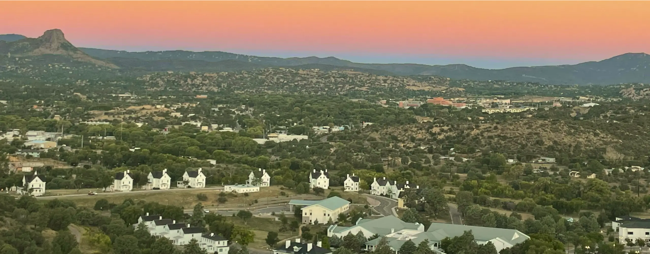 An aerial view of a town with mountains in the background.