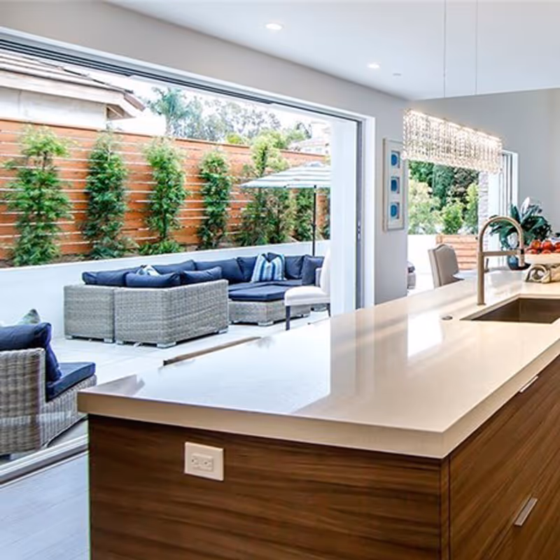modern kitchen looking out 2 large patio pocket doors to a courtyard.