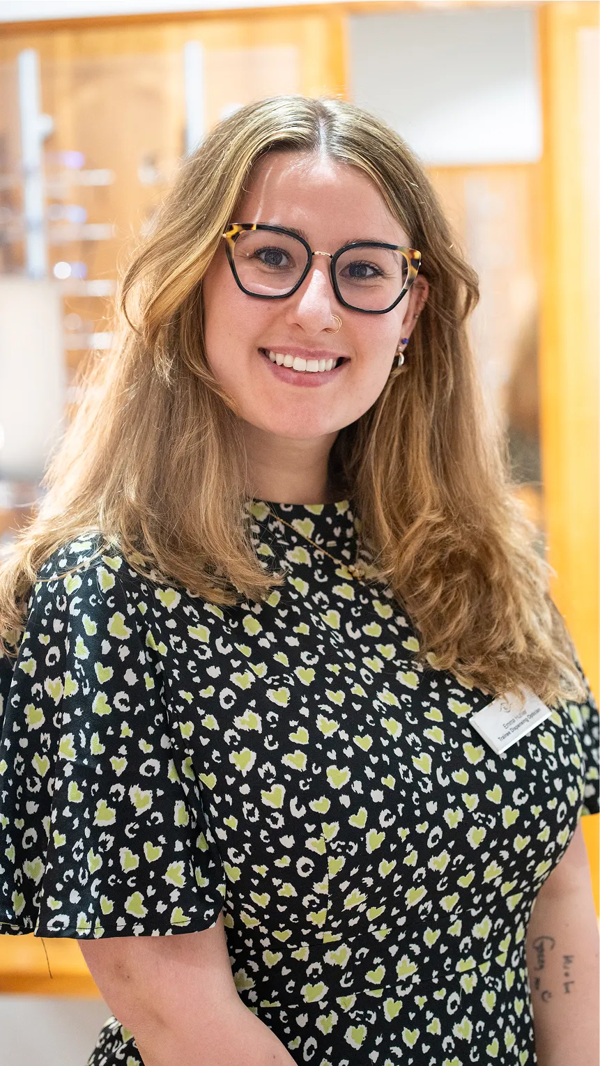 Smiling professional wearing glasses and patterned blouse in office setting