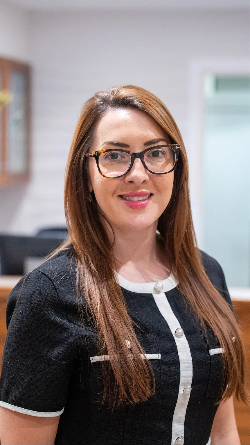Professional woman in black and white dress smiling in office