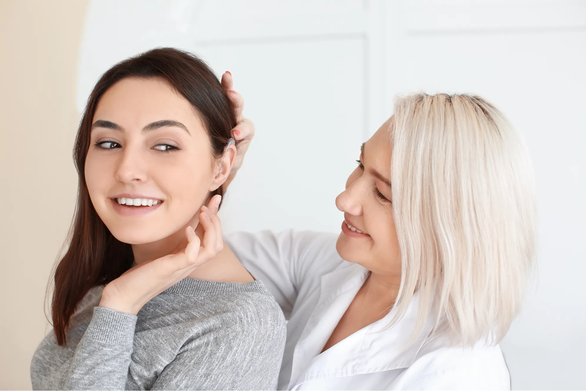 Two women smiling and touching faces, showing friendship and connection