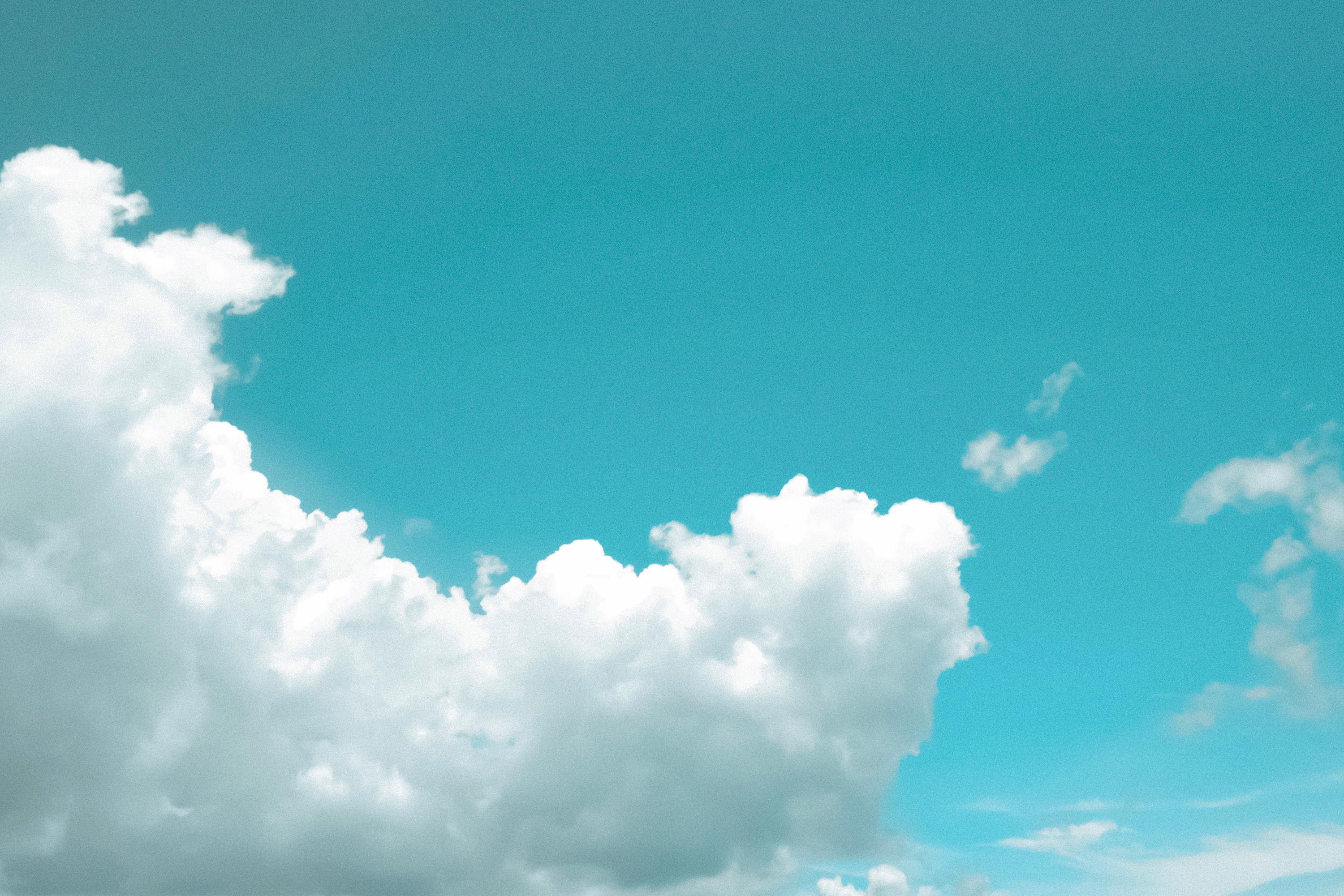 Soft, fluffy white clouds filling a bright blue sky.