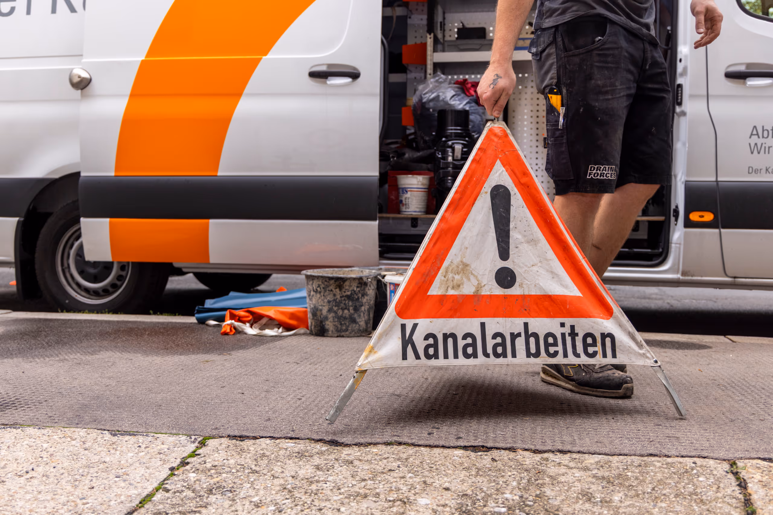 Arbeiter in Sicherheitsausrüstung bei Kanalbauarbeiten in der Baugrube