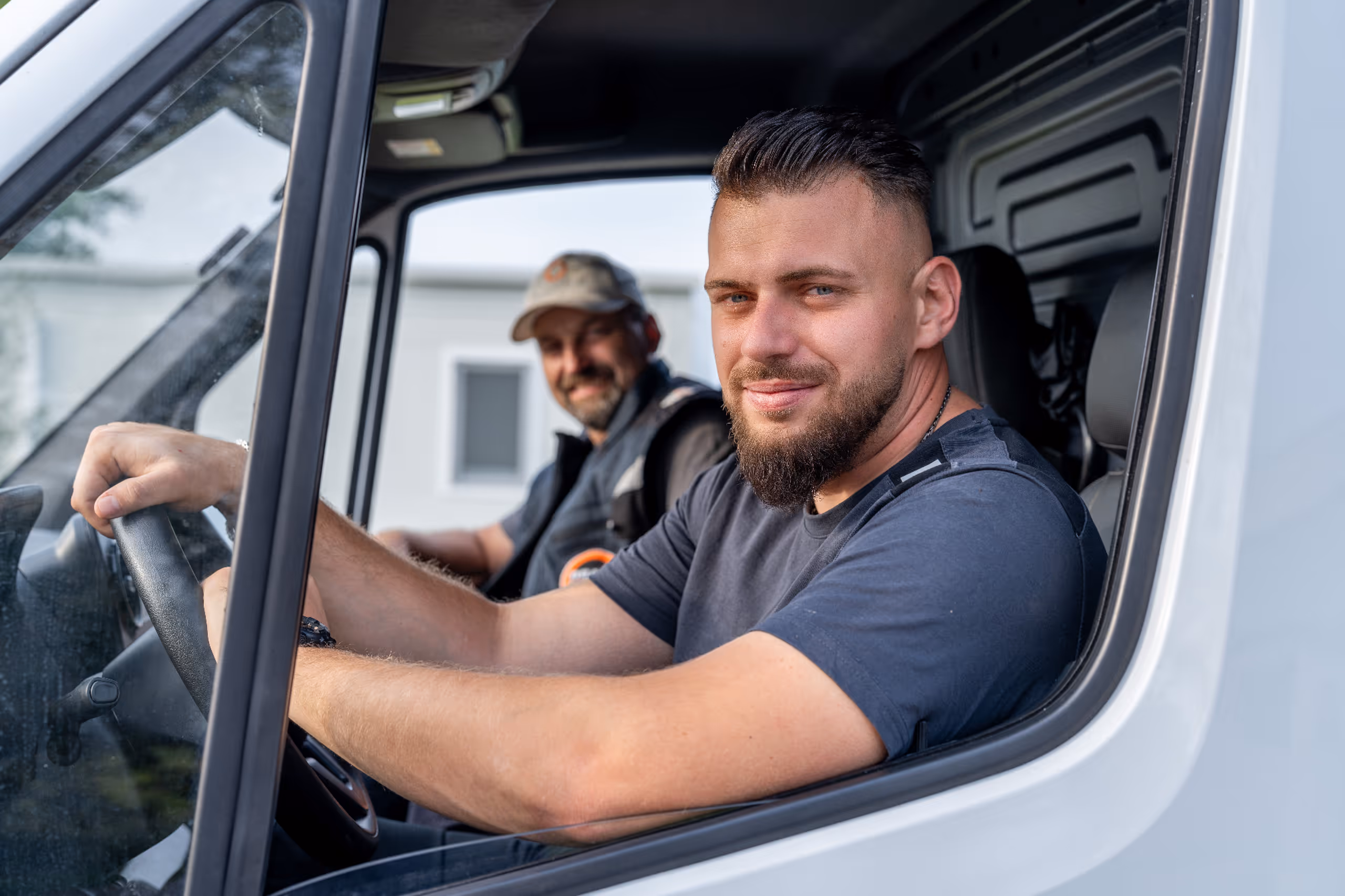 Arbeiter in orangen Sicherheitswesten bei der Kanalrohrverlegung