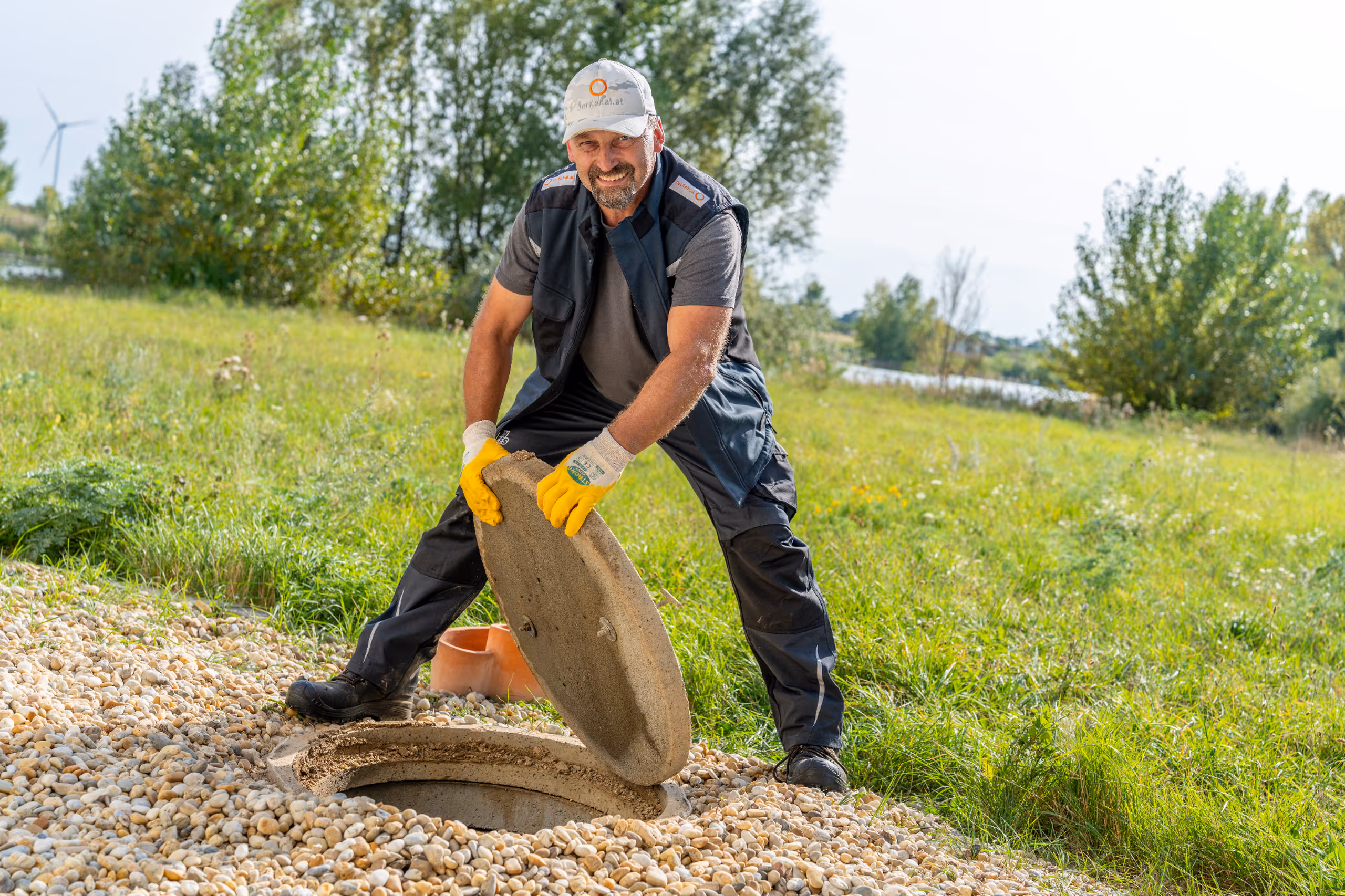 Bagger hebt Kanalrohre in eine vorbereitete Baugrube