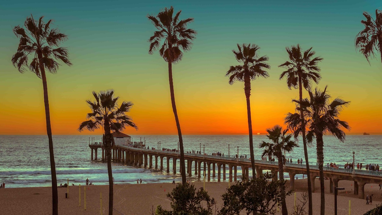 Manhattan Beach Pier at sunset with palm trees, representing the Southern California lifestyle and clarity offered by Golden Grove Law PC.