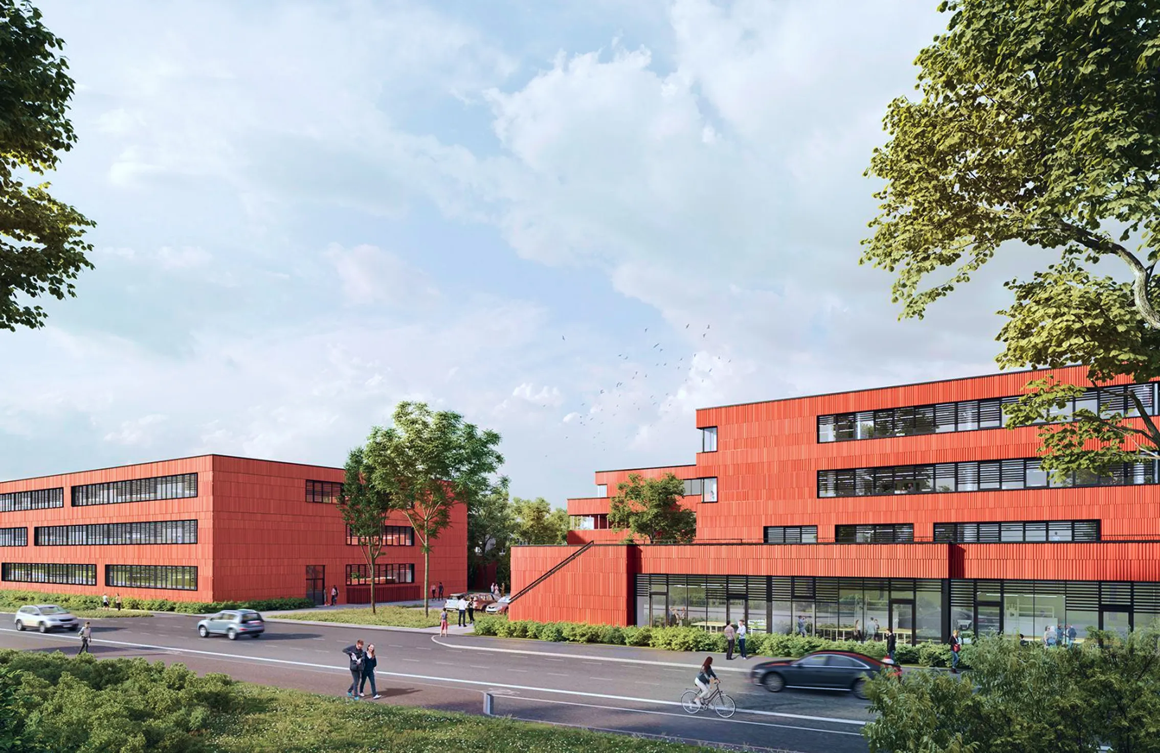 Moderne rote Bürogebäude mit großen Fenstern entlang einer Straße mit Autos, Radfahrer und Fußgängern, umgeben von Bäumen und Grünflächen.