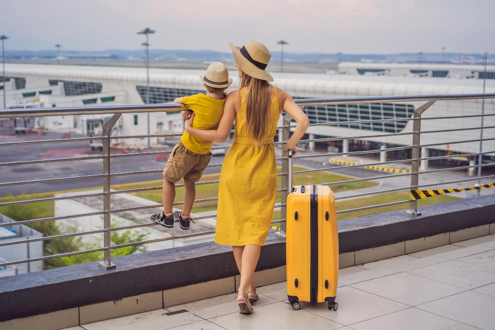 woman with luggage looking out over an airport terminal preparing to travel to Australia