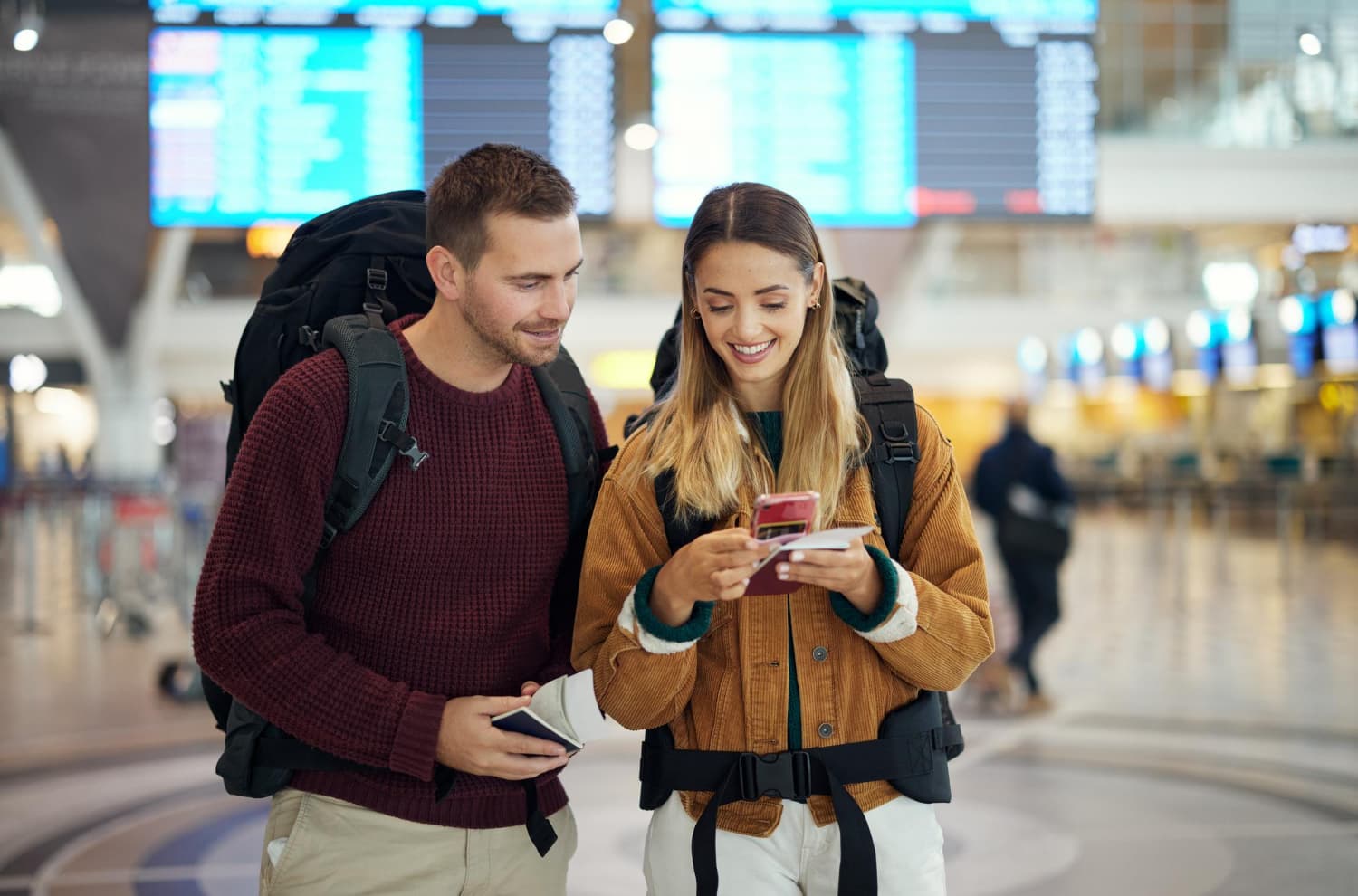 Couple at airport checking passport and phone before travelling to Australia together