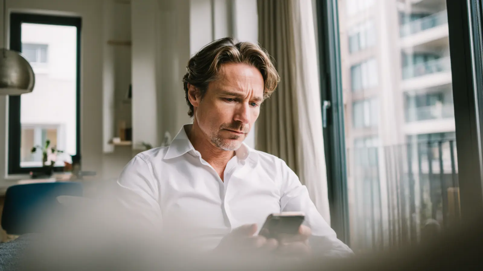 Un chef d'entreprise ou gestionnaire de société de nettoyage utilise son smartphone pour valider la conformité de ces agents de nettoyage Clindit.