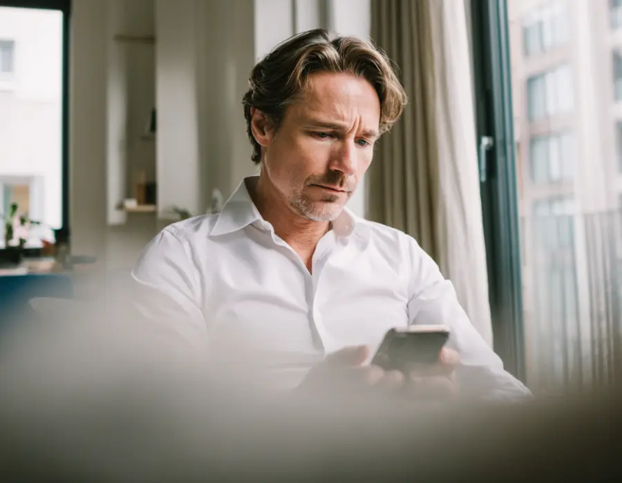 Un chef d'entreprise ou gestionnaire de société de nettoyage utilise son smartphone pour valider la conformité de ces agents de nettoyage Clindit.