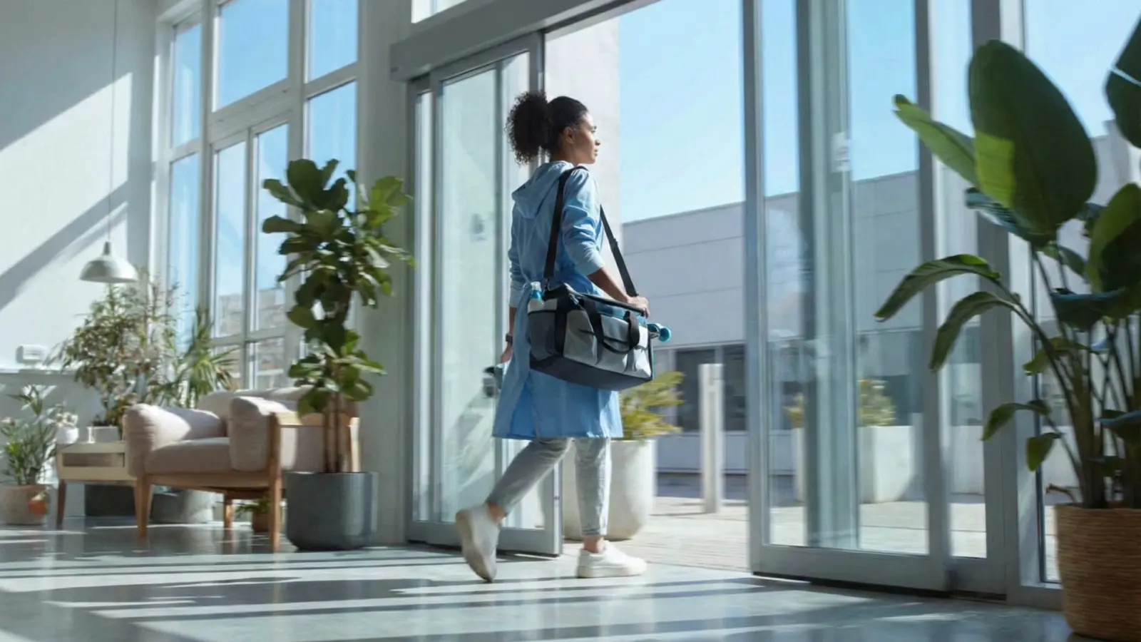 Agent de propreté Clindit arrivant dans des bureaux modernes avec son équipement pour assurer l'entretien des locaux en remplacement d'un agent absent.